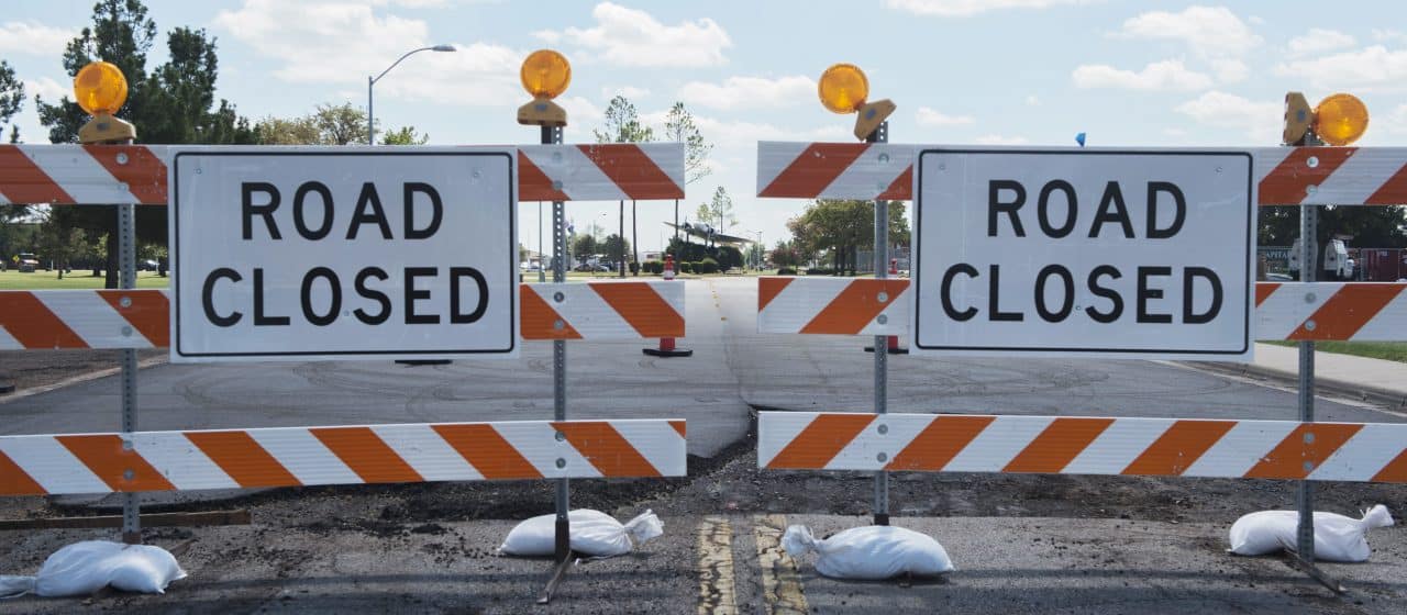 Barricades indicating road closure ahead.