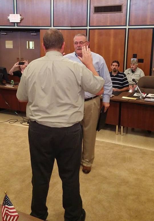 Person swearing in at a formal meeting.