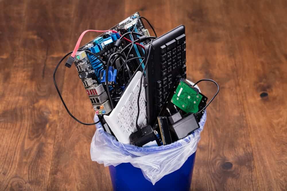 Discarded electronic components in a trash bin.