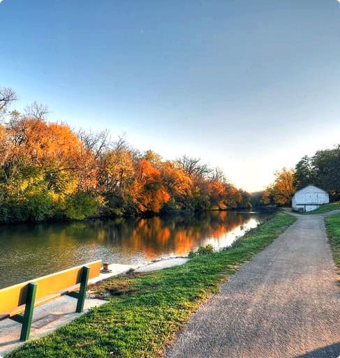 Scenic river view with autumn colors and path.